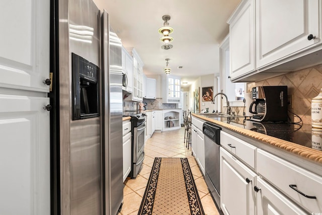 kitchen featuring light tile patterned floors, stainless steel appliances, decorative light fixtures, white cabinets, and sink