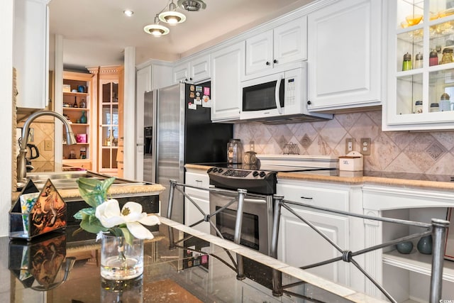 kitchen with stainless steel appliances, tasteful backsplash, light stone countertops, white cabinets, and sink