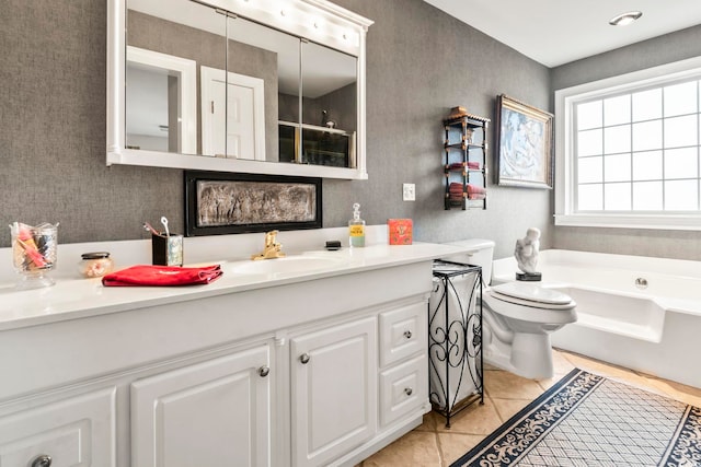 bathroom featuring toilet, tile patterned flooring, a washtub, and vanity