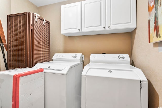 washroom with washing machine and dryer and cabinets