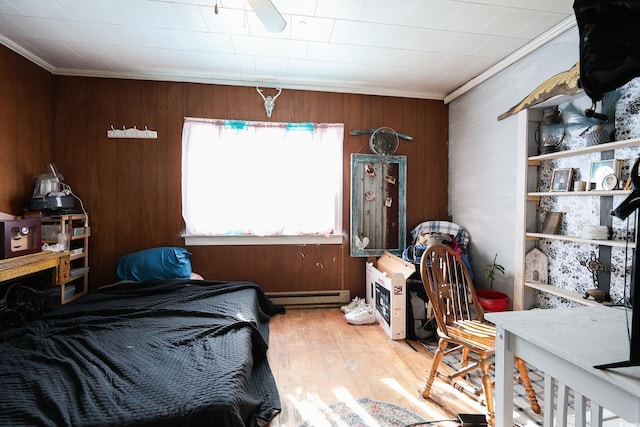 bedroom with a baseboard heating unit, wood walls, and crown molding