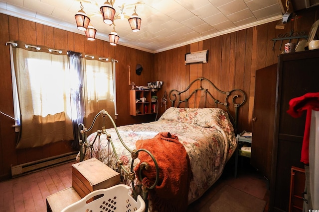 bedroom featuring wood-type flooring, wood walls, baseboard heating, and crown molding