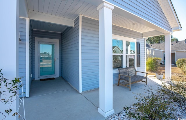 view of exterior entry featuring covered porch