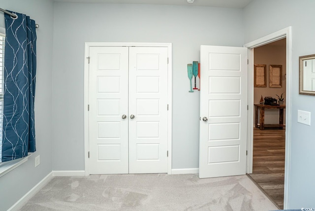 unfurnished bedroom with light colored carpet and a closet