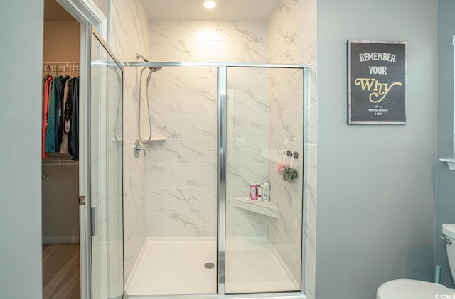 bathroom featuring an enclosed shower and toilet