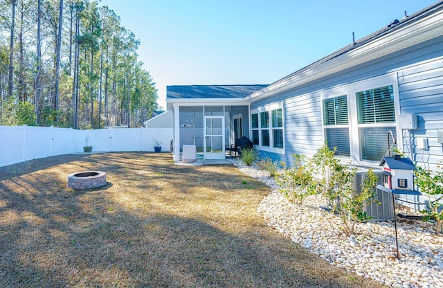 view of yard with a sunroom and an outdoor fire pit