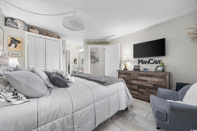 bedroom with light tile patterned floors, a textured ceiling, and a closet