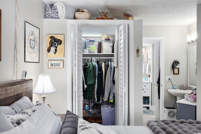 bedroom featuring sink, a closet, and a textured ceiling