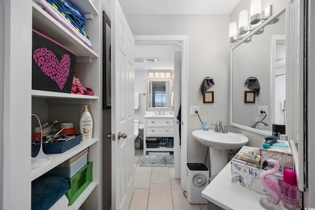 bathroom featuring tile patterned flooring, sink, and a textured ceiling