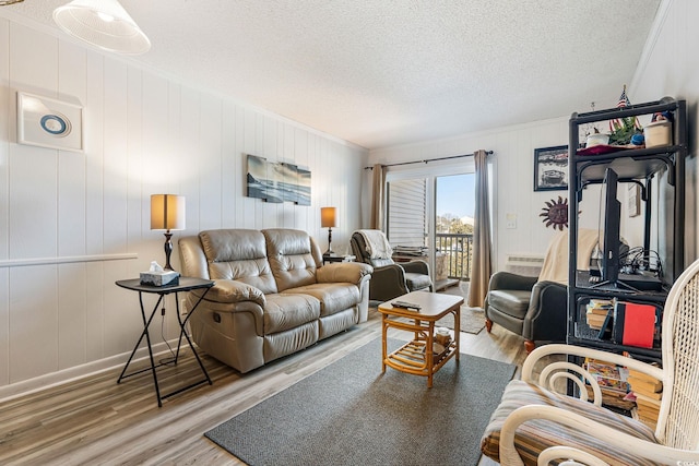 living room featuring a textured ceiling, crown molding, and hardwood / wood-style flooring