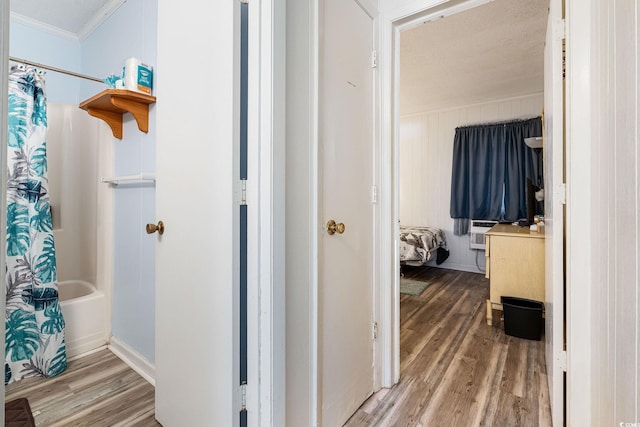 bathroom with wood-type flooring, shower / bath combination with curtain, ornamental molding, and a textured ceiling