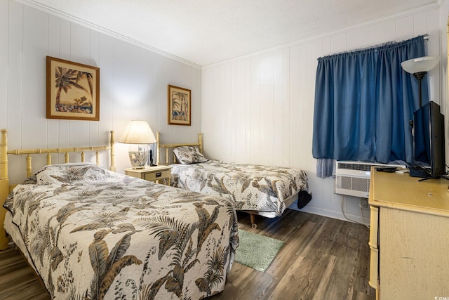 bedroom with a textured ceiling, ornamental molding, and dark hardwood / wood-style floors