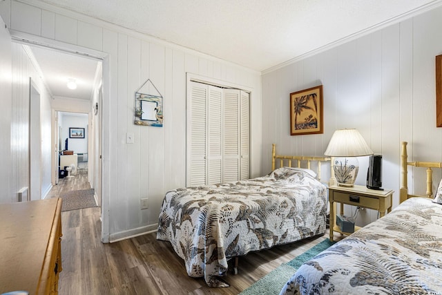 bedroom featuring a textured ceiling, crown molding, a closet, and dark hardwood / wood-style flooring