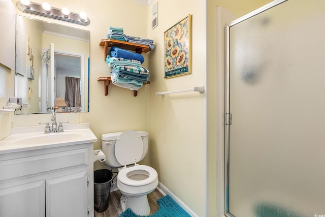 bathroom featuring a shower with shower door, toilet, and vanity