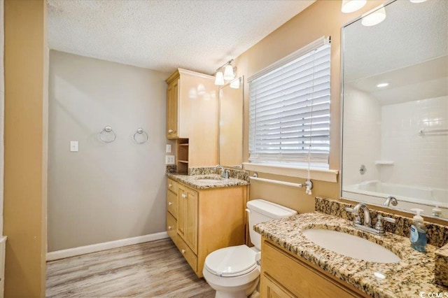 full bathroom featuring a textured ceiling, shower / tub combination, toilet, wood-type flooring, and vanity