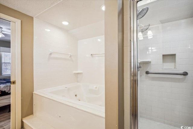 bathroom with a textured ceiling and separate shower and tub