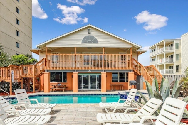 view of pool with grilling area and a wooden deck