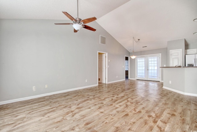 unfurnished living room with light hardwood / wood-style floors, french doors, high vaulted ceiling, and ceiling fan