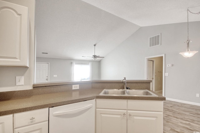 kitchen featuring dishwasher, lofted ceiling, white cabinetry, sink, and ceiling fan