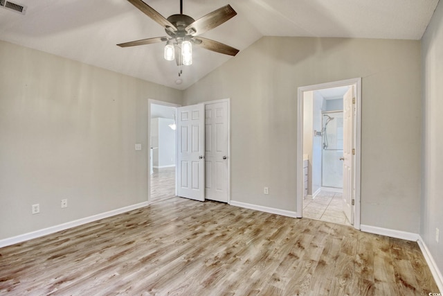 unfurnished bedroom with ensuite bath, ceiling fan, light wood-type flooring, and lofted ceiling