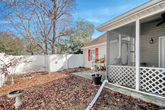 view of yard with ceiling fan, a sunroom, and a patio