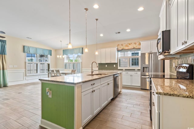 kitchen featuring hanging light fixtures, sink, white cabinets, a kitchen island with sink, and stainless steel appliances