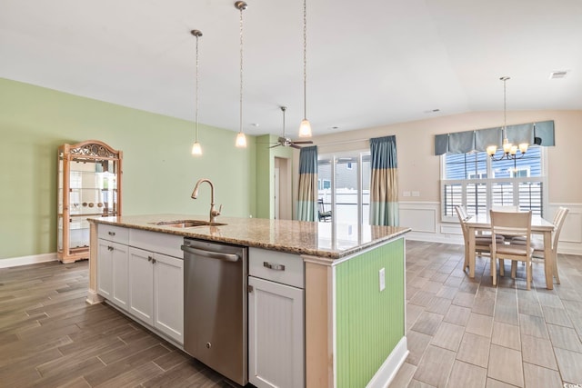 kitchen featuring pendant lighting, white cabinets, dishwasher, sink, and a kitchen island with sink