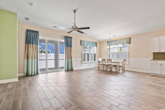 interior space featuring ceiling fan with notable chandelier and lofted ceiling