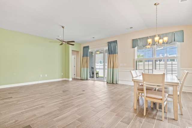 dining area with light hardwood / wood-style floors and ceiling fan with notable chandelier