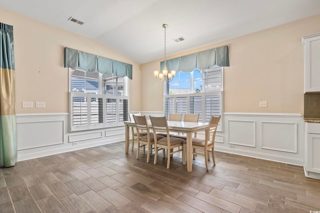 dining area featuring lofted ceiling and a chandelier