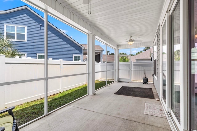 unfurnished sunroom with ceiling fan