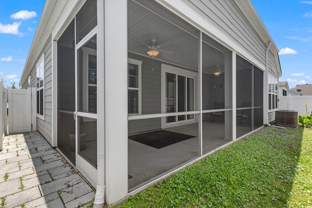 view of side of property with ceiling fan, central AC unit, and a sunroom