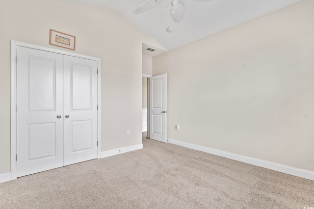 unfurnished bedroom with lofted ceiling, light colored carpet, a closet, and ceiling fan