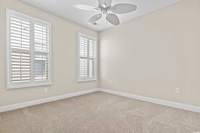 spare room featuring a healthy amount of sunlight, carpet floors, and ceiling fan