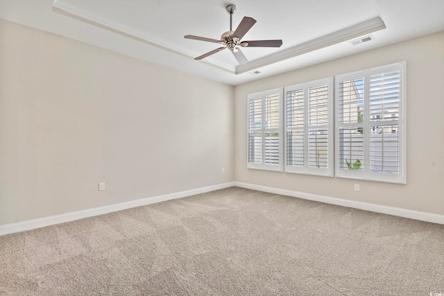 spare room with ceiling fan, carpet floors, and a tray ceiling