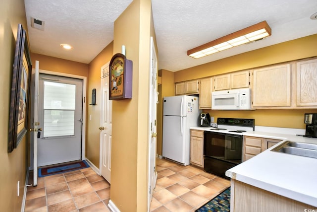 kitchen with a textured ceiling, light brown cabinets, white appliances, visible vents, and light countertops