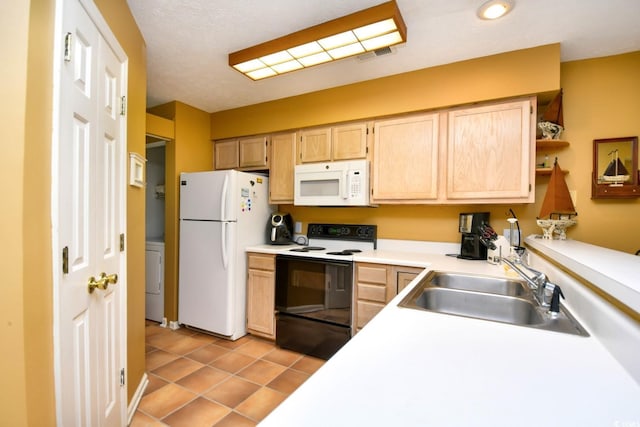 kitchen with white appliances, visible vents, a sink, and light brown cabinetry