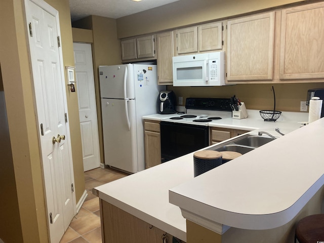 kitchen with light tile patterned floors, a peninsula, white appliances, a breakfast bar, and light countertops