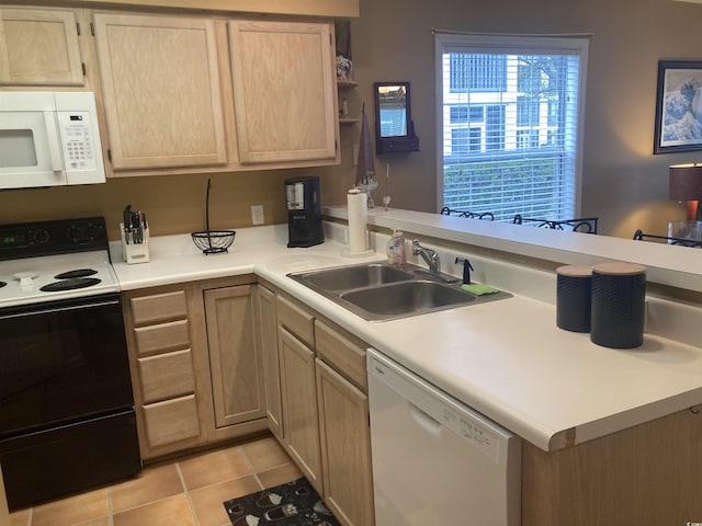 kitchen featuring white appliances, light tile patterned floors, a peninsula, light countertops, and a sink