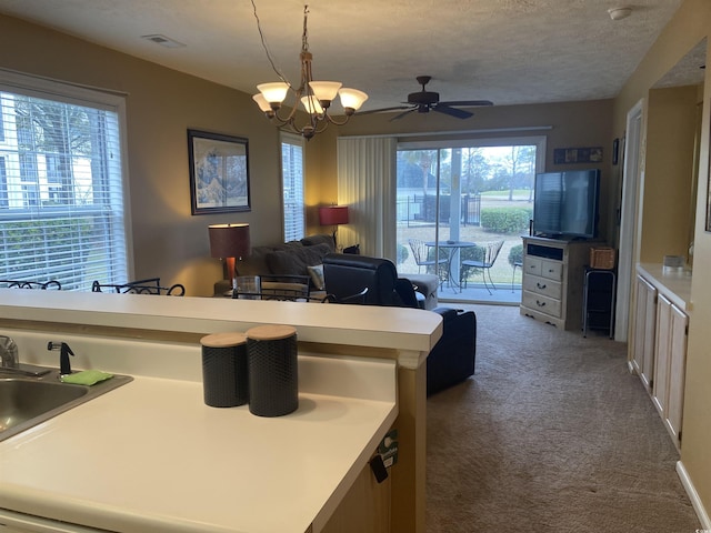 kitchen with light countertops, hanging light fixtures, visible vents, carpet flooring, and a textured ceiling