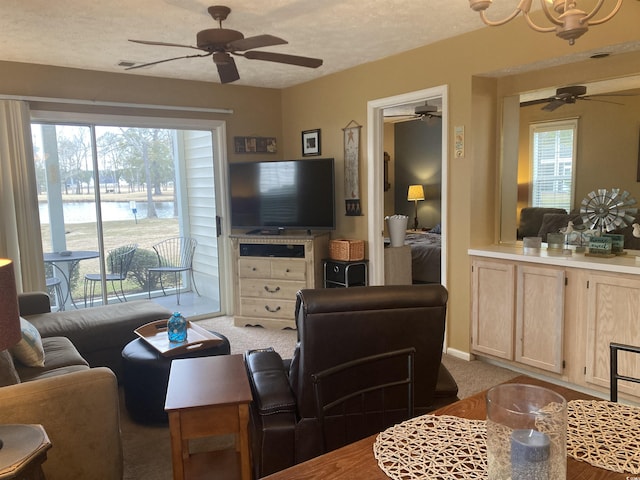 living room featuring carpet, ceiling fan, and a textured ceiling