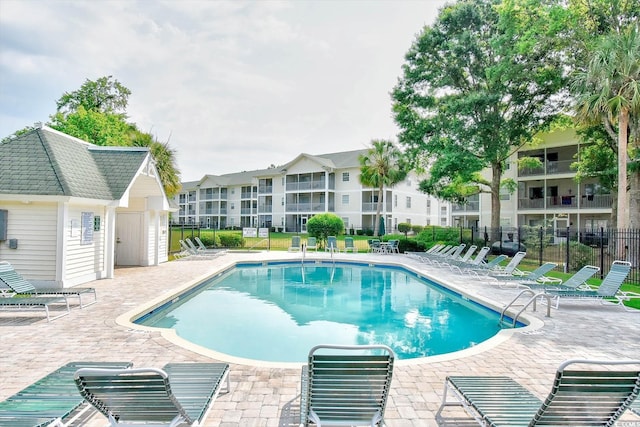 community pool featuring a patio area and fence