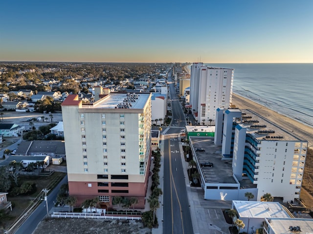 aerial view at dusk featuring a beach view and a water view