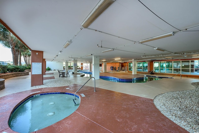 view of swimming pool featuring an indoor hot tub