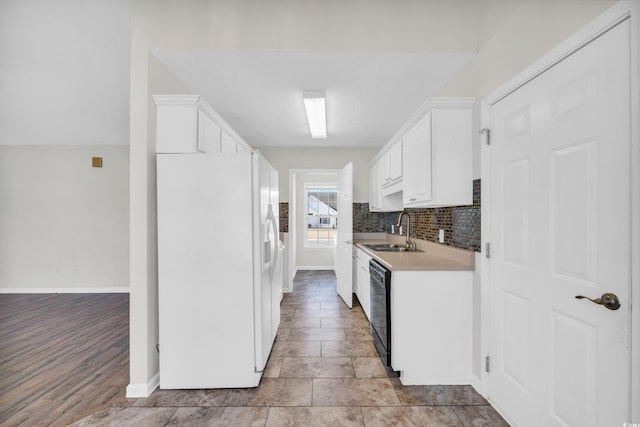 kitchen with dishwasher, decorative backsplash, sink, white cabinetry, and white refrigerator with ice dispenser