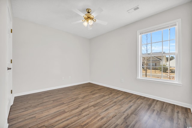 spare room featuring dark wood-type flooring and ceiling fan