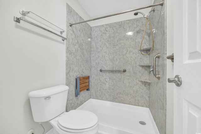 bathroom featuring toilet and tiled shower