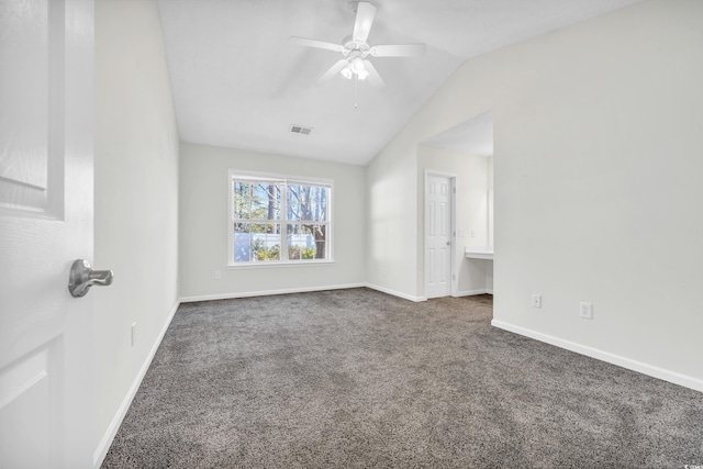 spare room with ceiling fan, vaulted ceiling, and dark colored carpet