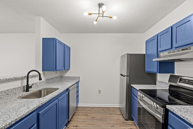 kitchen with sink, appliances with stainless steel finishes, and blue cabinetry