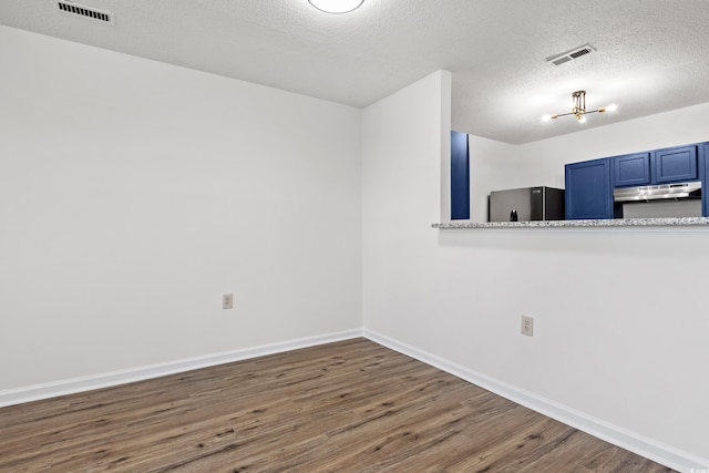 empty room with a textured ceiling and dark wood-type flooring